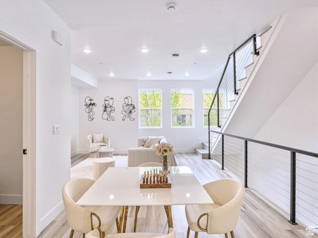dining room with recessed lighting, baseboards, stairway, and light wood-type flooring