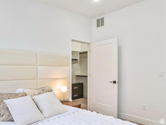 bedroom with visible vents, baseboards, a spacious closet, and a closet