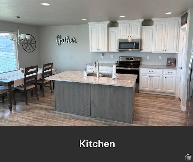 2447 N 2950 W, Plain City, UT 84404 - kitchen with stainless steel appliances, a chandelier, light wood-type flooring, recessed lighting, and white cabinetry