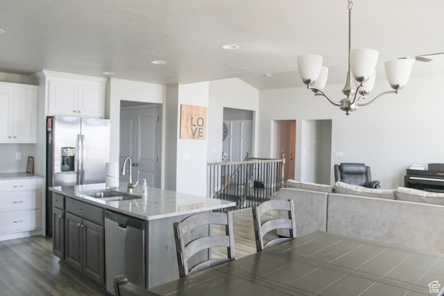 2447 N 2950 W, Plain City, UT 84404 - kitchen with stainless steel appliances, a sink, white cabinets, dark wood finished floors, and a chandelier