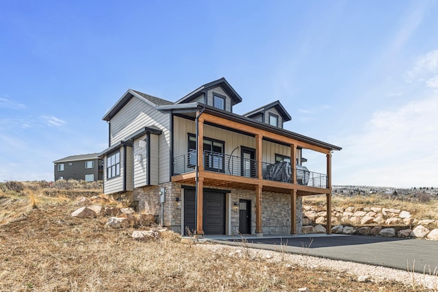 3467 S Porcupine Cir, Garden City, UT 84028 - back of house with a garage, board and batten siding, a balcony, and stone siding