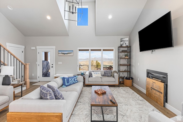 3467 S Porcupine Cir, Garden City, UT 84028 - living room featuring baseboards, high vaulted ceiling, wood finished floors, and stairway