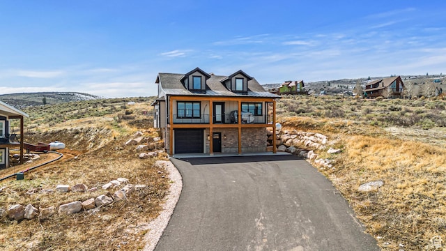 3467 S Porcupine Cir, Garden City, UT 84028 - view of front of property featuring a standing seam roof, a garage, a balcony, aphalt driveway, and stone siding