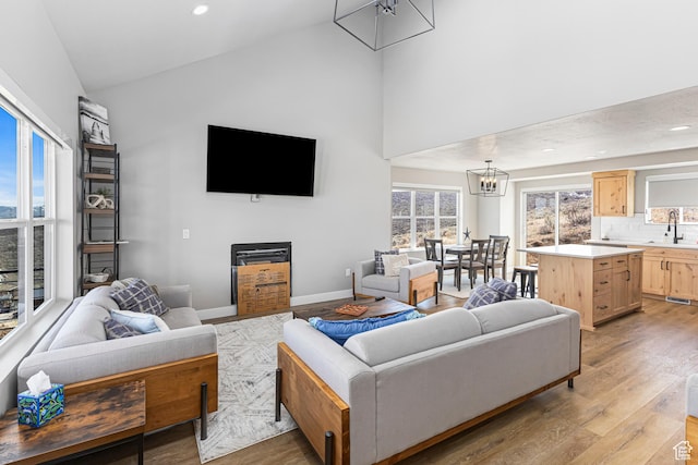3467 S Porcupine Cir, Garden City, UT 84028 - living area featuring recessed lighting, high vaulted ceiling, light wood finished floors, and a notable chandelier