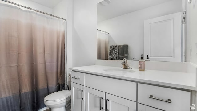 bathroom featuring toilet, curtained shower, and vanity
