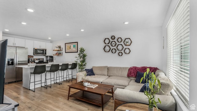 living area with recessed lighting and light wood-style flooring
