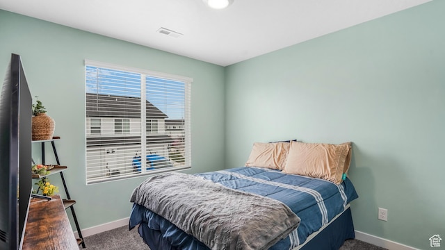 bedroom with baseboards, visible vents, and carpet