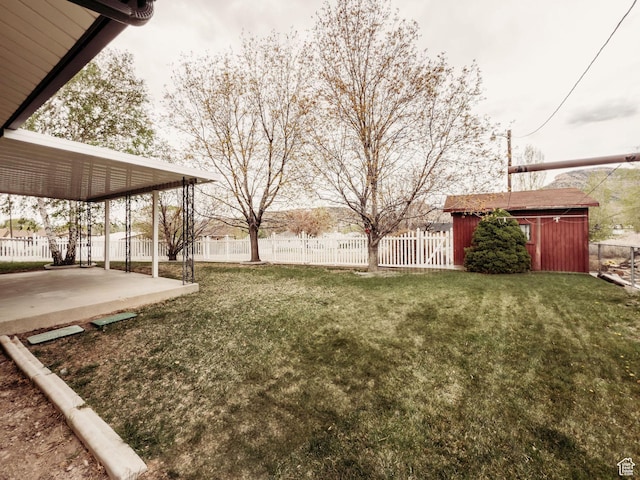 view of yard featuring a patio, fence, and an outdoor structure