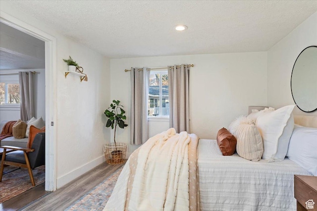 555 15th St, Ogden, UT 84404 - bedroom featuring a textured ceiling, baseboards, multiple windows, and wood finished floors