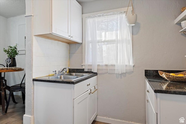 555 15th St, Ogden, UT 84404 - kitchen with a sink, dark countertops, white cabinets, and wood finished floors