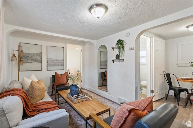 555 15th St, Ogden, UT 84404 - living area featuring arched walkways, a textured ceiling, visible vents, and wood finished floors