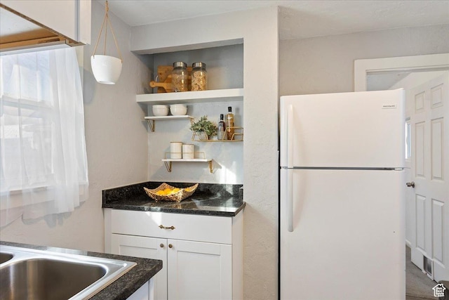 555 15th St, Ogden, UT 84404 - kitchen featuring freestanding refrigerator, white cabinetry, open shelves, and dark stone countertops
