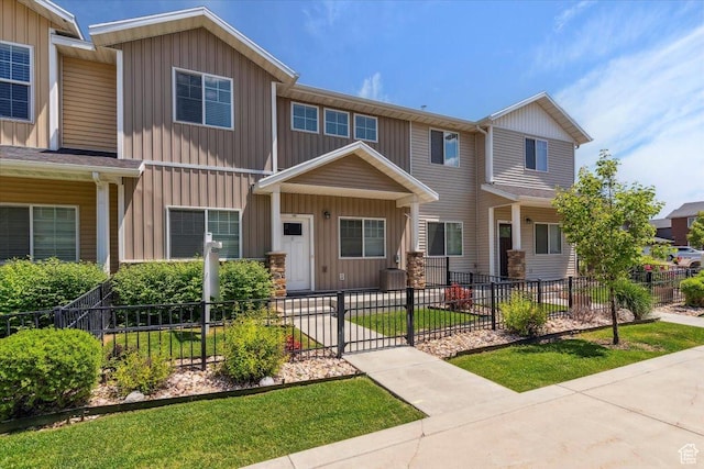 1545 N 420 W Unit 103, Logan, UT 84341 - view of front of property featuring a fenced front yard, central air condition unit, and board and batten siding
