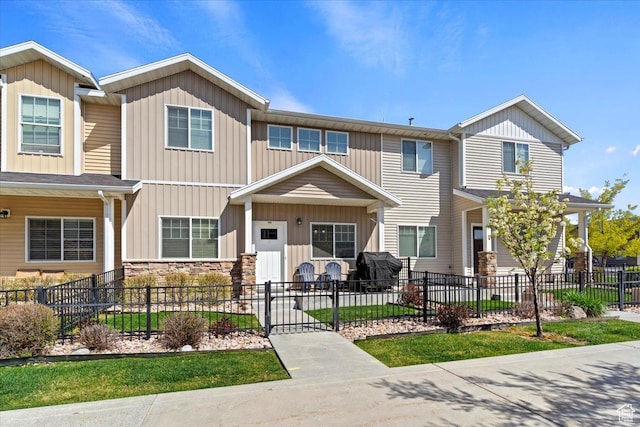 1545 N 420 W Unit 103, Logan, UT 84341 - view of front facade featuring board and batten siding, a fenced front yard, and stone siding