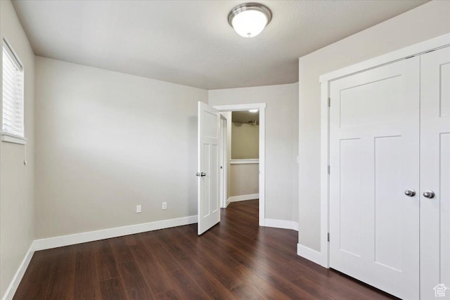 1545 N 420 W Unit 103, Logan, UT 84341 - unfurnished bedroom featuring dark wood-type flooring, baseboards, and a closet