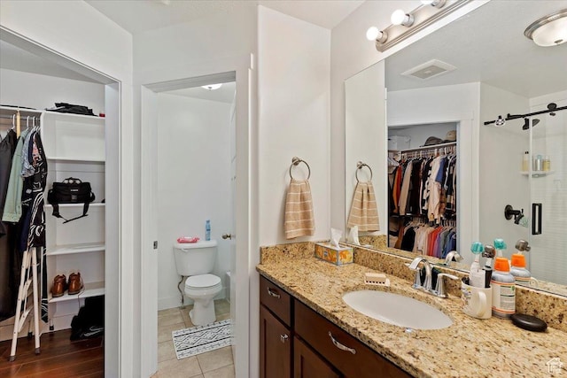 1545 N 420 W Unit 103, Logan, UT 84341 - bathroom with visible vents, a stall shower, vanity, toilet, and a spacious closet