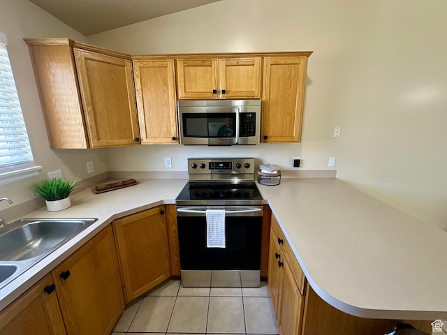 819 E 725 N, Ogden, UT 84404 - kitchen with appliances with stainless steel finishes, light countertops, a peninsula, light tile patterned floors, and vaulted ceiling