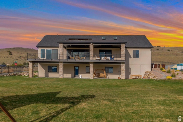 6433 N Glenmar Way, Eagle Mountain, UT 84005 - rear view of property featuring fence, a balcony, stone siding, stucco siding, and a yard