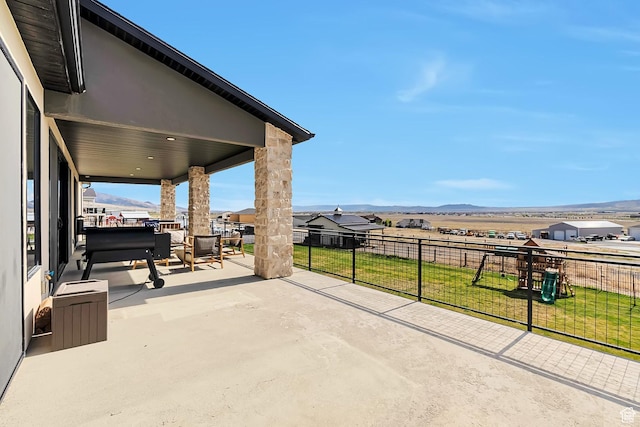 6433 N Glenmar Way, Eagle Mountain, UT 84005 - view of patio / terrace featuring fence, a mountain view, and a playground