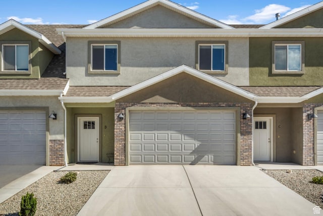 3154 W 1650 N Unit D, Cedar City, UT 84721 - townhome / multi-family property featuring a shingled roof, brick siding, a garage, stucco siding, and concrete driveway