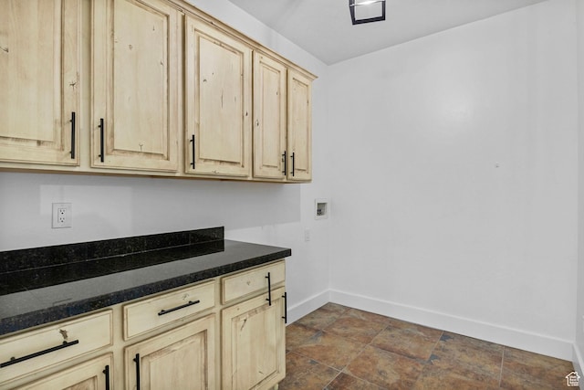 laundry room with baseboards, hookup for a washing machine, cabinet space, and stone finish flooring