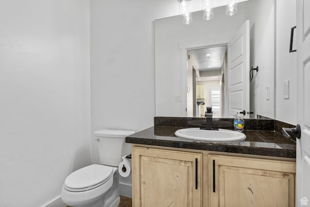 half bath featuring toilet and vanity