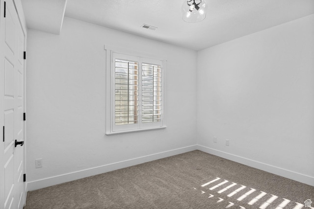 carpeted spare room with baseboards and visible vents