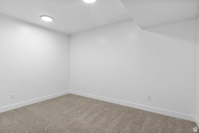 carpeted empty room featuring baseboards