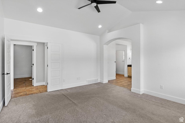 unfurnished bedroom with carpet flooring, arched walkways, recessed lighting, baseboards, and lofted ceiling