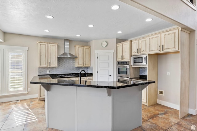 kitchen with stainless steel appliances, baseboards, wall chimney exhaust hood, and light brown cabinets