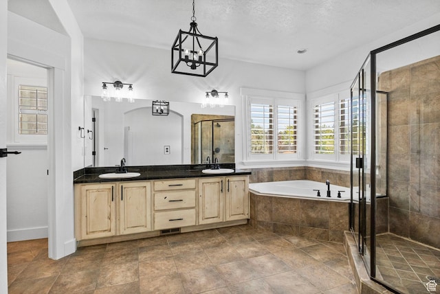 full bathroom with double vanity, a shower stall, a sink, and a garden tub