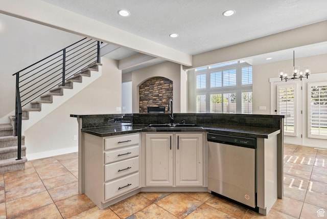 kitchen with stainless steel dishwasher, a sink, recessed lighting, and an inviting chandelier