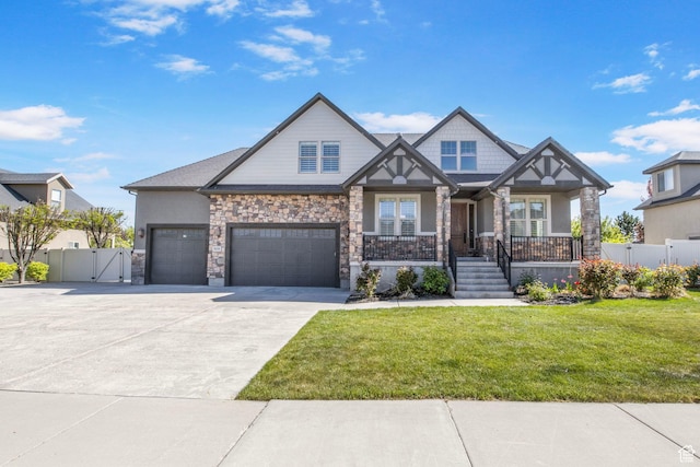 craftsman-style house with a porch, a front yard, a gate, fence, and stone siding