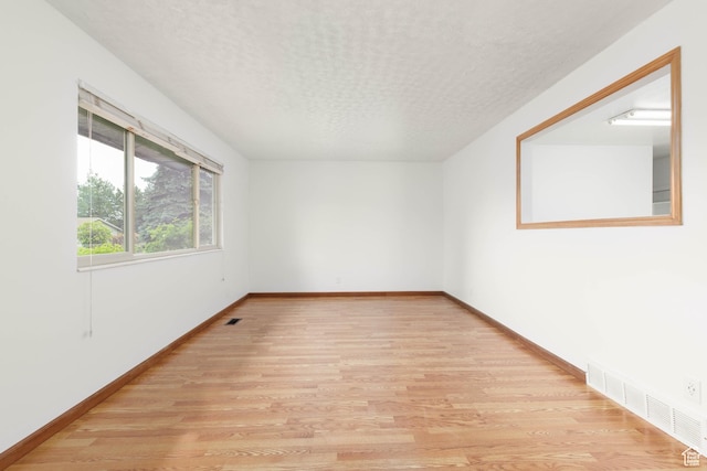 5550 Westside Dr, Kearns, UT 84118 - unfurnished room featuring visible vents, a textured ceiling, baseboards, and light wood-type flooring