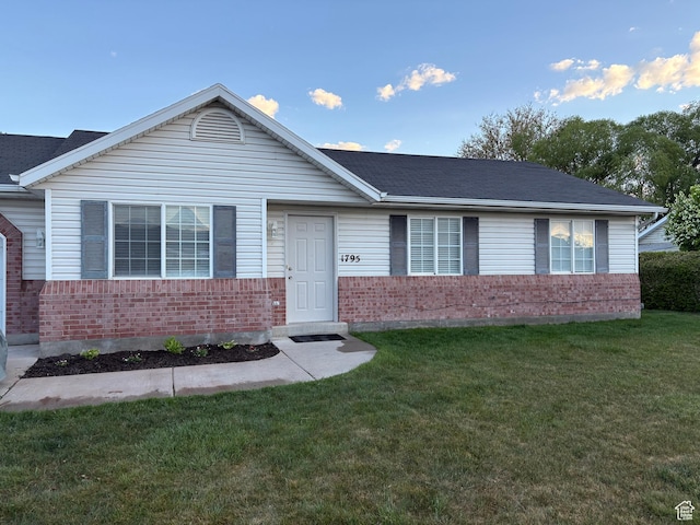 single story home with roof with shingles, a front lawn, and brick siding