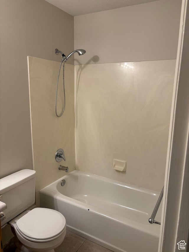 full bath with tile patterned flooring, washtub / shower combination, and toilet