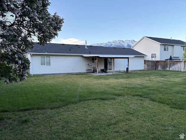 rear view of house featuring fence, a patio, and a yard