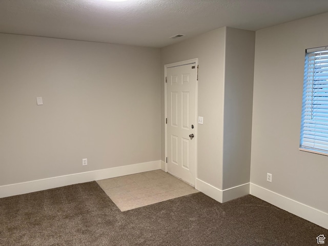 unfurnished room with visible vents, carpet flooring, and baseboards