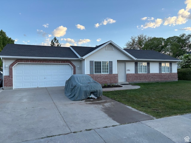 ranch-style house with brick siding, a front lawn, an attached garage, and concrete driveway
