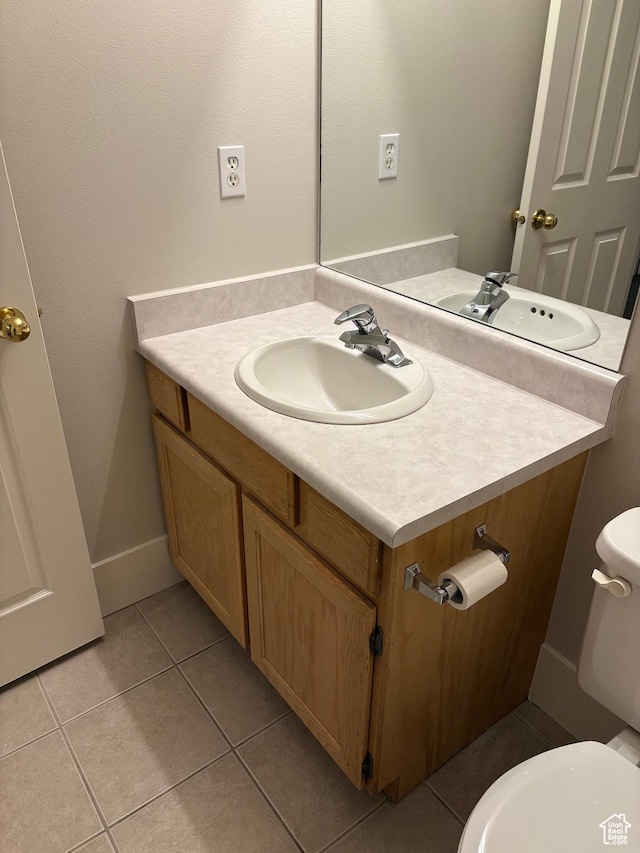 bathroom featuring vanity, tile patterned flooring, and toilet
