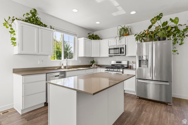 5829 N Goldfinch Ln, Stansbury Park, UT 84074 - kitchen featuring appliances with stainless steel finishes, a sink, a center island, white cabinetry, and dark wood-type flooring