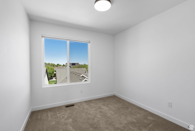 carpeted spare room with baseboards and visible vents
