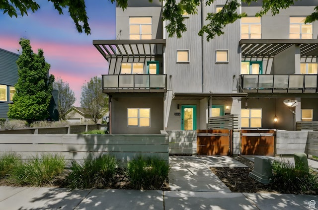 rear view of property with fence and a balcony