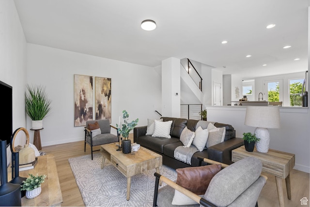 living area featuring recessed lighting, light wood finished floors, and baseboards