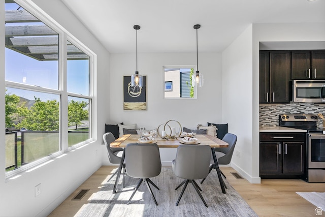 dining area with light wood-style floors and visible vents