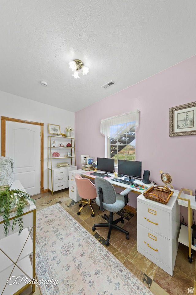 office space with a textured ceiling and visible vents