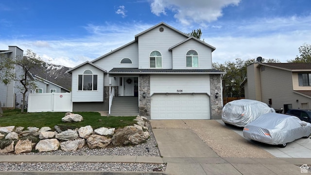 5026 S 1150 E, South Ogden, UT 84403 - view of front facade featuring fence, an attached garage, a front lawn, stone siding, and concrete driveway