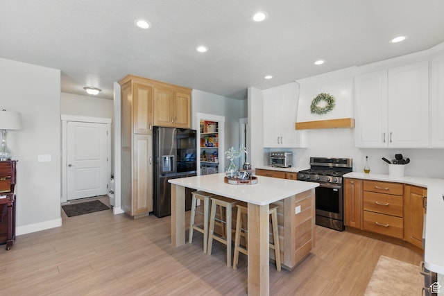 1147 N Carriage Ln, Spanish Fork, UT 84660 - kitchen featuring a kitchen bar, a center island, light countertops, light wood-style flooring, and appliances with stainless steel finishes