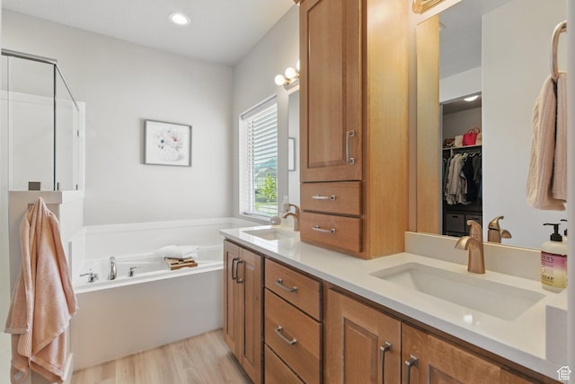 1147 N Carriage Ln, Spanish Fork, UT 84660 - bathroom featuring double vanity, a sink, a garden tub, and wood finished floors