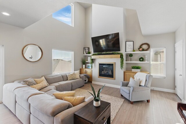 1147 N Carriage Ln, Spanish Fork, UT 84660 - living area featuring a glass covered fireplace, baseboards, light wood-style floors, and recessed lighting